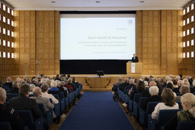 Das Foto zeigt den Vortragssaal der Akademie. Am Rednerpult steht ein Mann. 