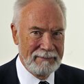 Ein Mann mit Bart schaut freundlich in die Kamera.