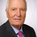 Ein Mann schaut lächelnd in die Kamera.