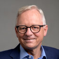 Ein Mann mit Brille lächelt in die Kamera.