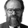 Ein Mann mit Vollbart schaut freundlich in die Kamera. Er trägt eine Brille.