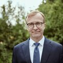 Ein Mann steht vor Strauchern.