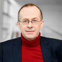 Ein Mann mit Brille schaut freundlich in die Kamera.
