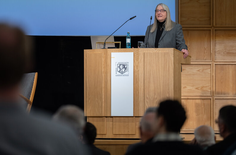 Eine Frau steht an einem Rednerpult.