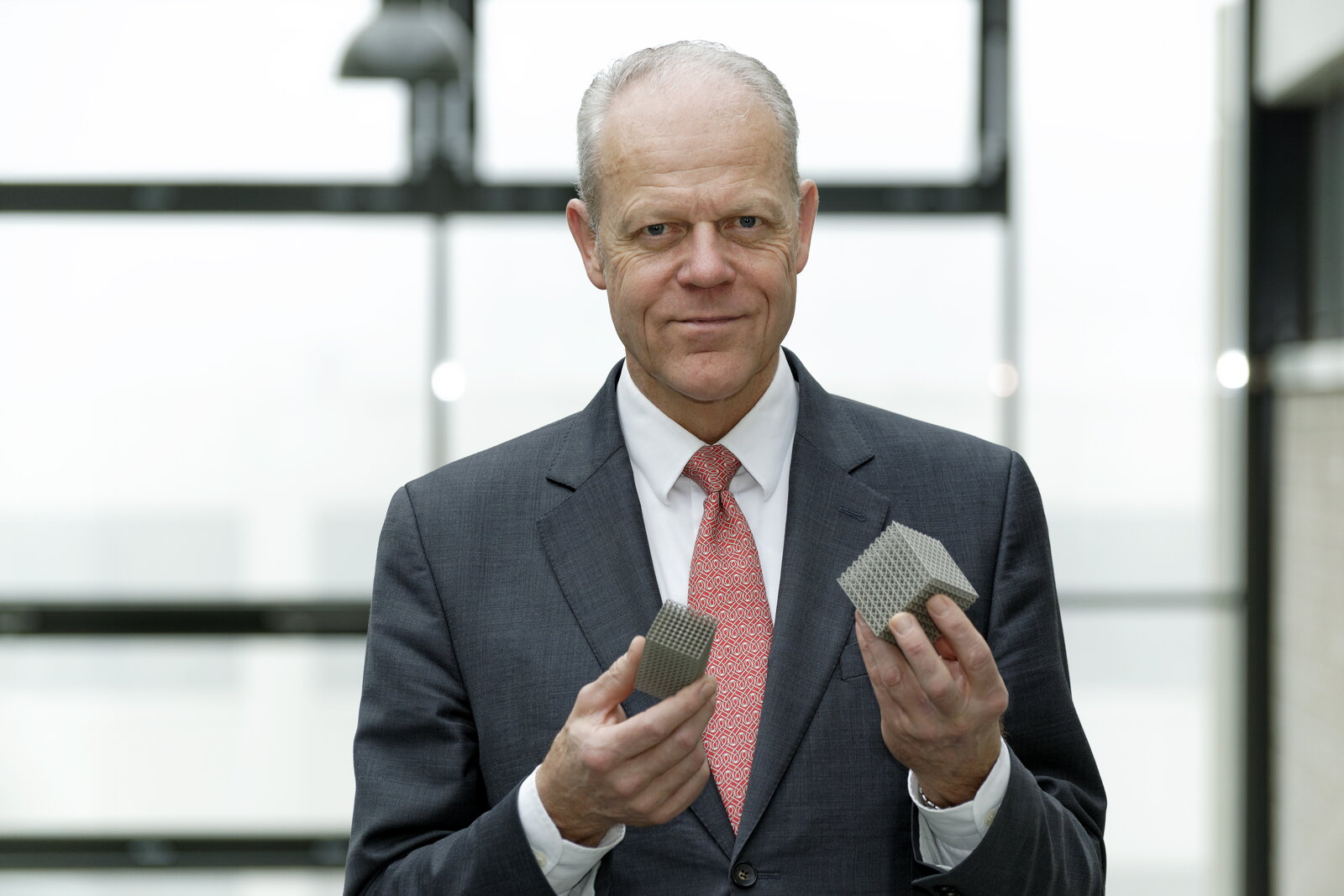 Ein Mann hält viereckige Metallstrukturen in den Händen