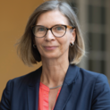 Eine Frau mit Brille und halblangen Haaren lächelt in die Kamera.
