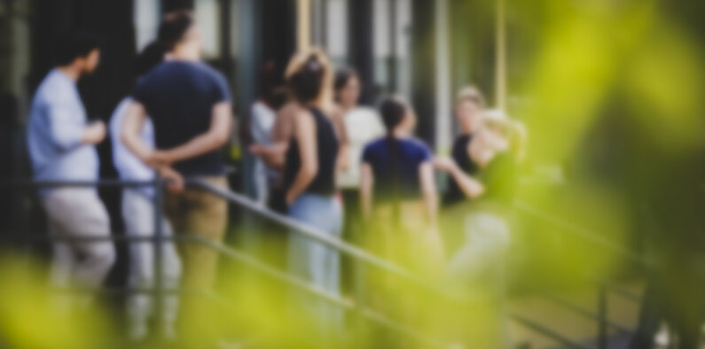 Menschen stehen auf einer Treppe und unterhalten sich.