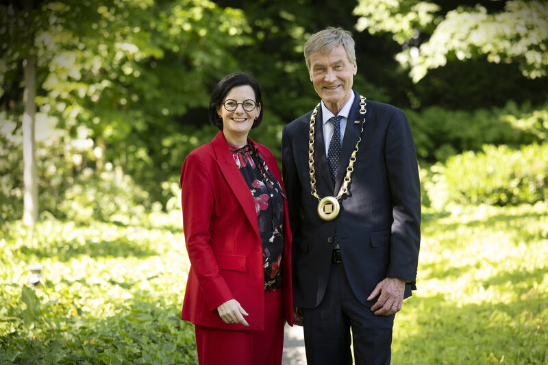 Ein Mann und eine Frau haben sich in einem Park für ein Foto aufgestellt.