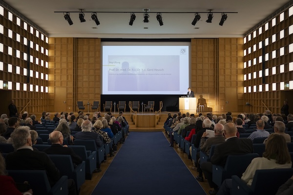 Ein gut gefüllter Veranstaltungssaal. Ein Mann steht am Rednerpult.