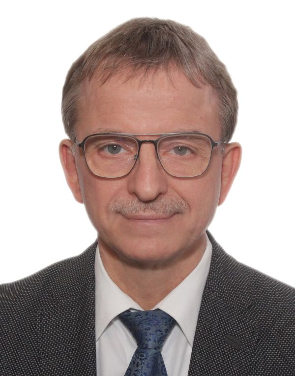 Mann mit Brille lächelt in die Kamera.