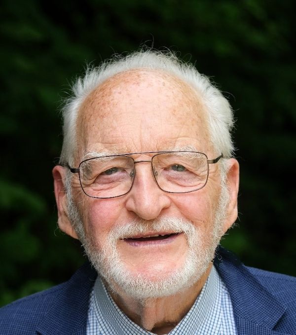 Ein Mann mit Brille und Bart lächelt in die Kamera.