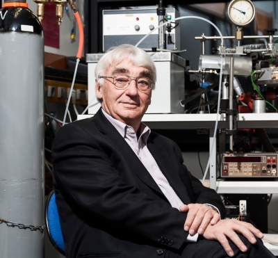 Ein Mann mit Brille sitzt vor technischen Geräten. Er schaut freundlich in die Kamera.