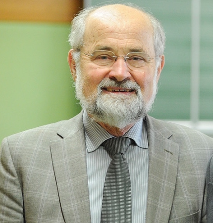 Ein Mann mit randloser Brille lächelt in die Kamera.