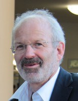Ein Mann mit Brille und Bart schaut freundlich in die Kamera.